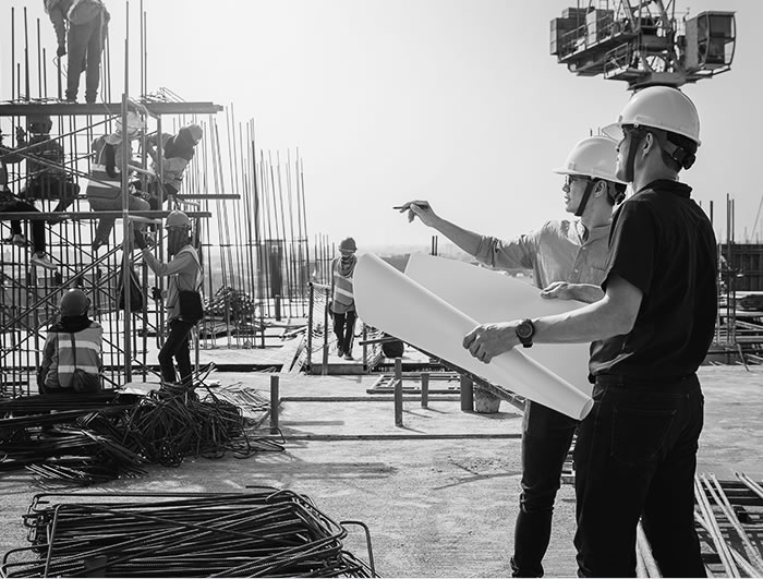 Engenheiros da Futura analisando a planta no canteiro de obras